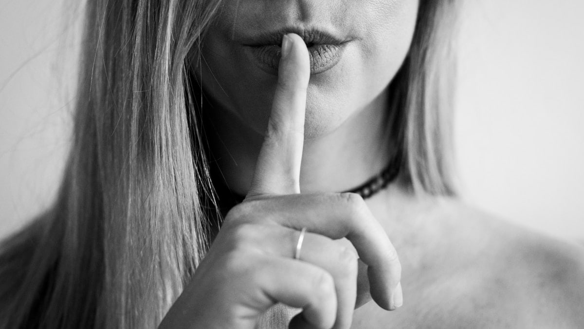 a woman making a hush with her finger